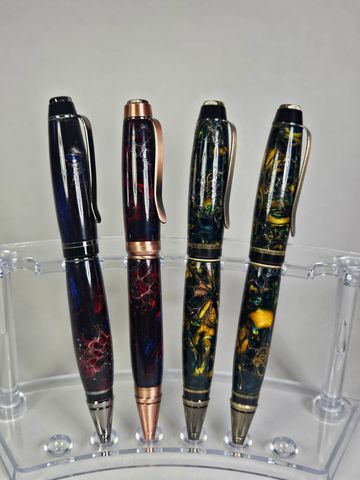 Four elegant, colorful pens displayed upright.