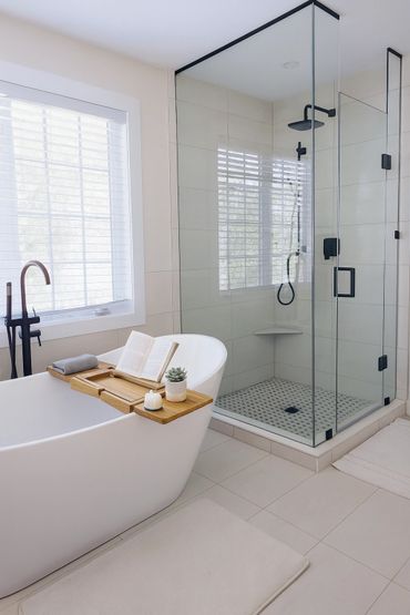 Modern bathroom with a white bathtub and glass shower enclosure.