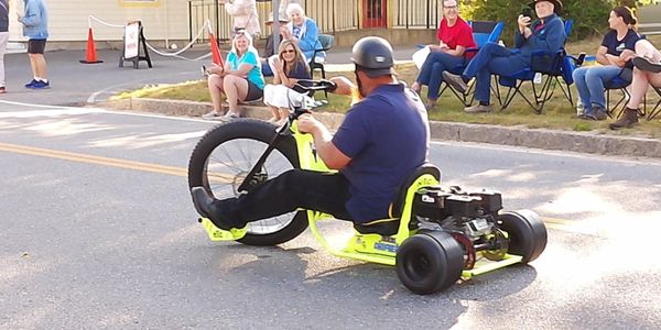 Man riding a motorized drift trike on the street.