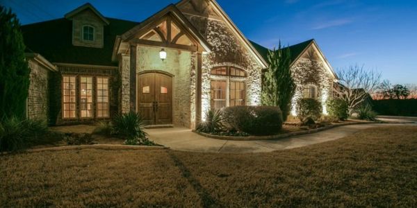 Custom home with a rock exterior and accent light.