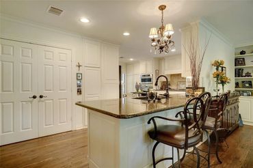 Residential addition. Kitchen with custom painted cabinets, granite countertops, and hardwood floors
