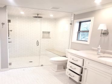 Master bathroom with white tile, Carrera marble counter tops, tile floor, and walking shower