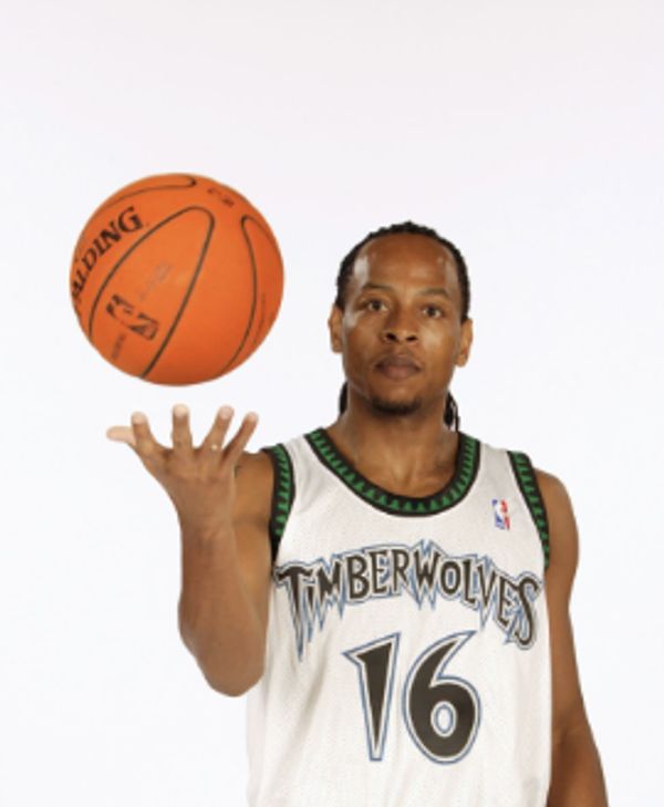 Basketball player in Timberwolves jersey spinning a basketball.