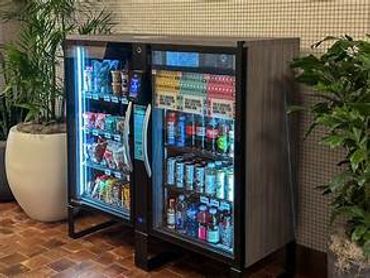 Glass-door cooler stocked with various beverages and snacks indoors.