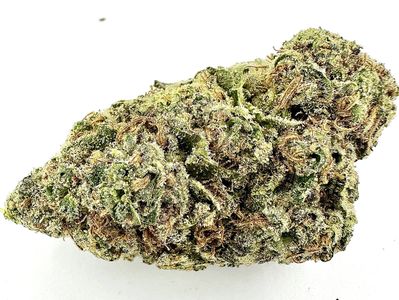 Close-up of a dense cannabis bud with green and orange hues.