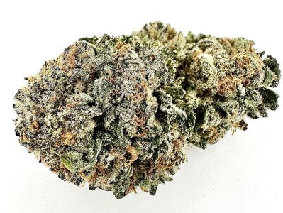 Close-up of a frosty cannabis bud with orange hairs and green leaves.