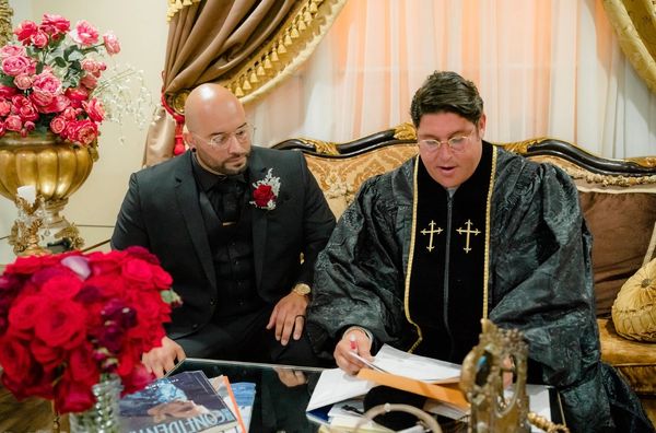 two men in black robes signing a document