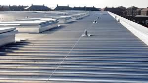 Long metal rooftop with vents and a cable running across it.