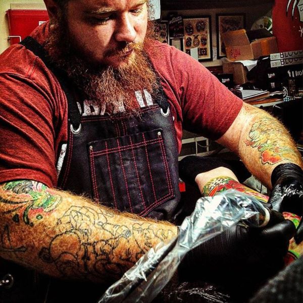 Tattoo artist focused on inking a client's arm in a vibrant studio.