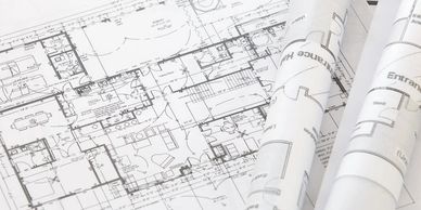 Architectural blueprints and rolled-up floor plans on a desk.
