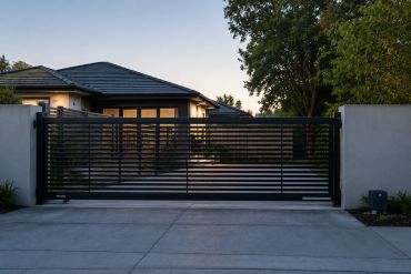 Modern black metal gate at house entrance.