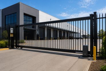 Modern warehouse behind a black automatic gate.