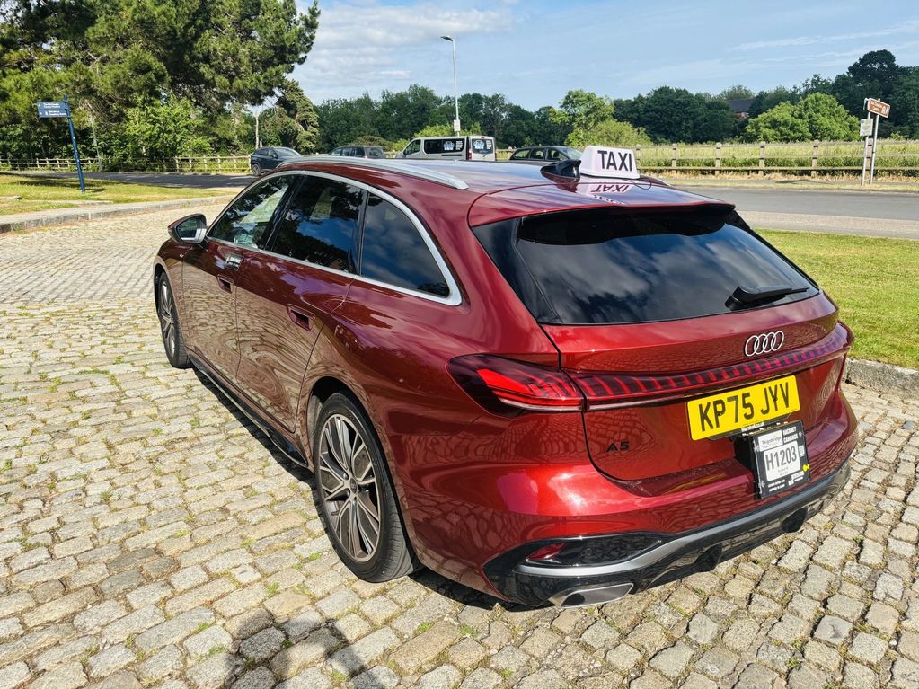 Red Audi A5 wagon taxi parked on a cobblestone street under a sunny sky.