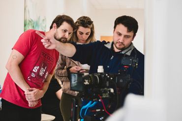 Crew member pointing out a shot beside a cinema camera on a New Orleans set