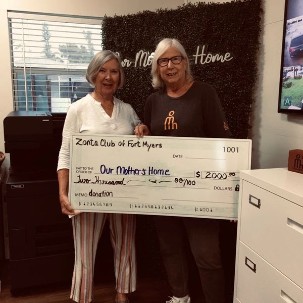 Board member awarding grant check to Our Mothers Home.