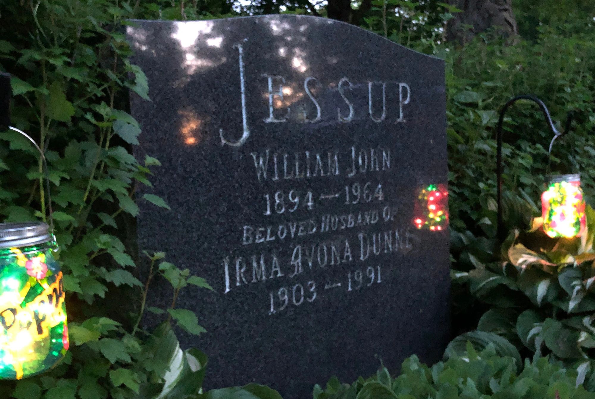 Photo of grave with headstone and  two memorial lights
