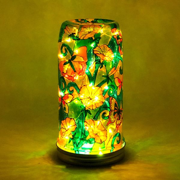 Battery light made from a mason jar with orange and yellow butterflies and flowers painted on the si