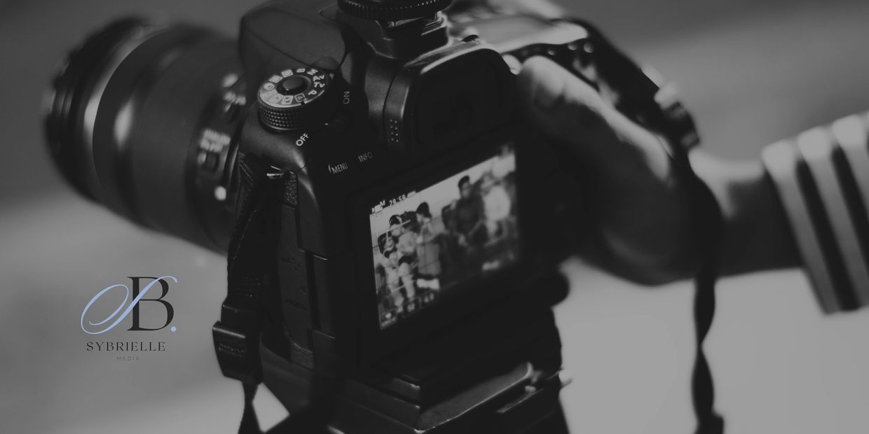 Close-up of a DSLR camera screen capturing a group photo in black and white.