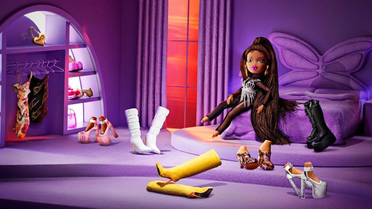 A stylish doll in a purple room surrounded by various fashionable shoes.