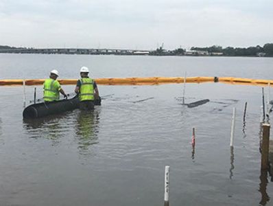 Contractors laying Grid Composite Solution in waist deep water