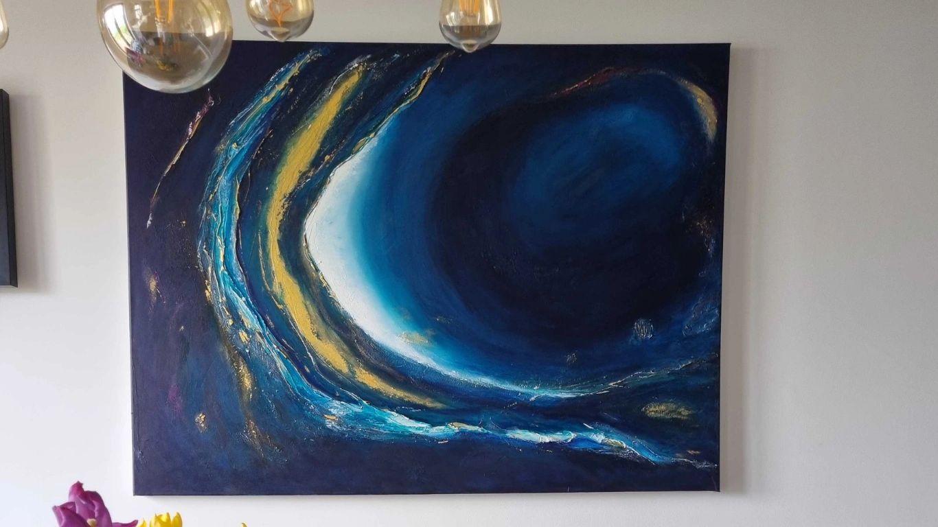 Abstract blue and gold painting on a white wall with hanging glass bulbs.