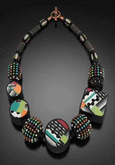 Necklace of hand formed polymer forms, and handwoven and layered glass beads. Steel wire.