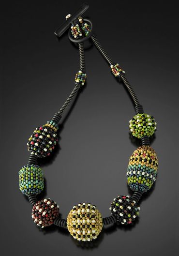 Necklace of handwoven and layered glass beads. Steel wire.