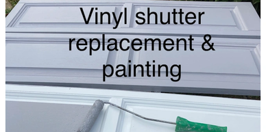 Vinyl shutter being painted gray with a roller.
