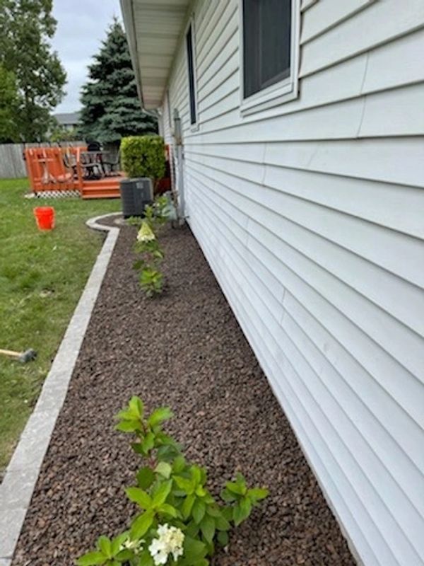 A flower bed in front of a house