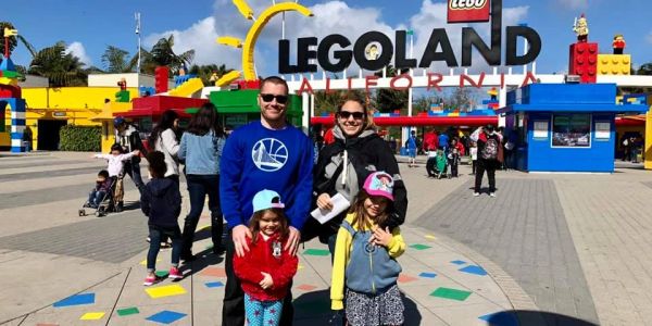 Family posing at Legoland California entrance.