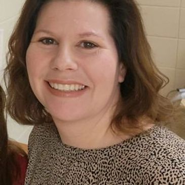Smiling woman with shoulder-length brown hair.