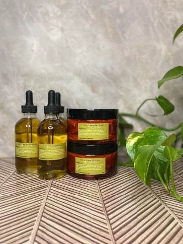 Bottles and jars of skincare products with a green plant.