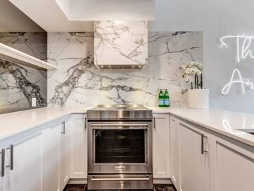 Kitchen renovation with Laminum tile in Whistler BC. Stainless steel appliances.