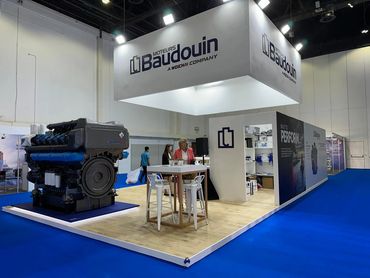 indoor exhibition stand in Dubai for Baudouin – bold design showcasing large industrial machines.