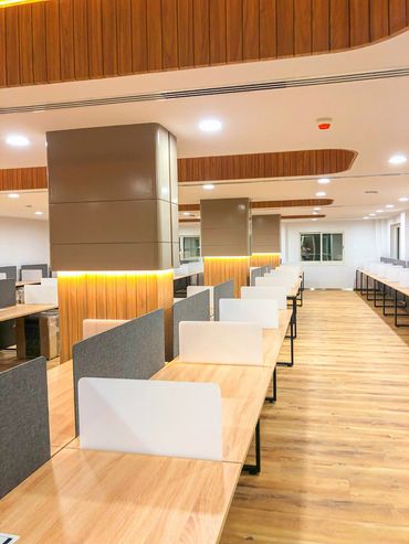 Corporate office interior design in Dubai with wood ergonomic furniture and  tables and partition