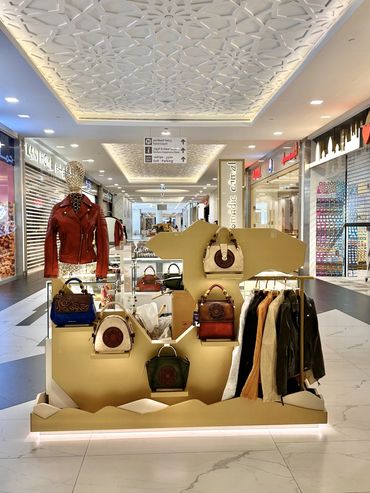 Custom retail kiosk by Fine Tune Interiors in Dubai, designed for showcasing bags and wallets.