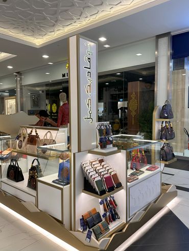 Custom retail kiosk by Fine Tune Interiors in Dubai, designed for showcasing bags and wallets.