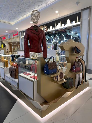 Custom retail kiosk by Fine Tune Interiors in Dubai, designed for showcasing bags and wallets.