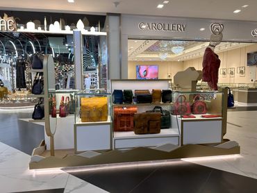 Custom retail kiosk by Fine Tune Interiors in Dubai, designed for showcasing bags and wallets.
