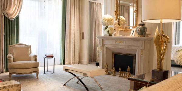 Elegant living room with classic armchair, ornate fireplace, and soft natural light.