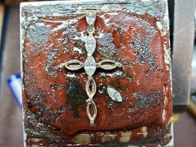 Stones are being set into the assembled mounting.