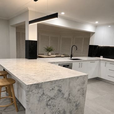 Modern kitchen with marble countertops and sleek design.