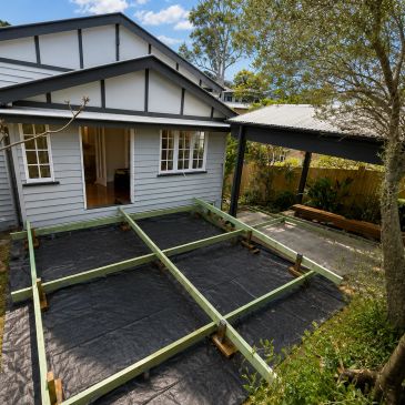 Backyard with wooden frame construction near a house.