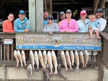 Group of people posing with their catch at Mickey's Bar & Grill in Texas.