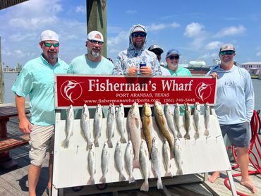 Group of men posing with their catch at Fisherman's Wharf in Port Aransas, Texas.