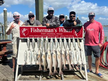 Six men proudly display their catch at Fisherman's Wharf in Port Aransas, Texas.