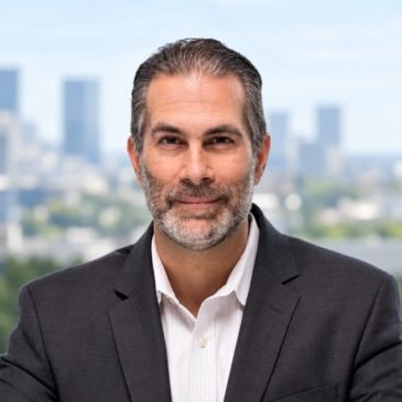 Confident businessman in suit with cityscape background.