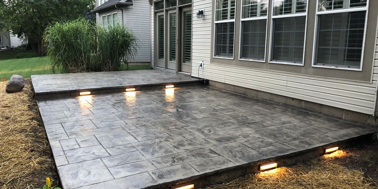 Stamped concrete back yard patio with step lighting