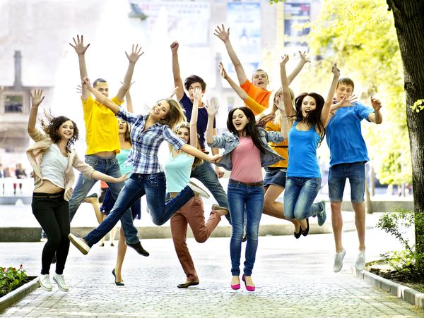Group of students jumping happily in the park