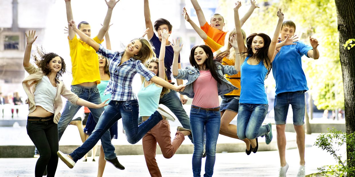 Group of students jumping happily in the park